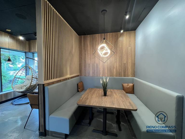 This Mississauga restaurant renovation features a semi-private booth seating area with custom millwork, wood panel accents, and integrated lighting. The layout creates a comfortable dining environment that enhances privacy while maintaining an open and modern restaurant interior.