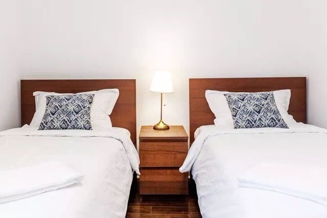This Toronto interior renovation features a bright and well-organized twin bedroom layout with matching beds, warm wooden headboards, and soft neutral décor. The symmetrical design and simple furnishings create a clean, comfortable environment ideal for guests or family members. The renovation highlights a functional and welcoming bedroom space suitable for modern Toronto home living.