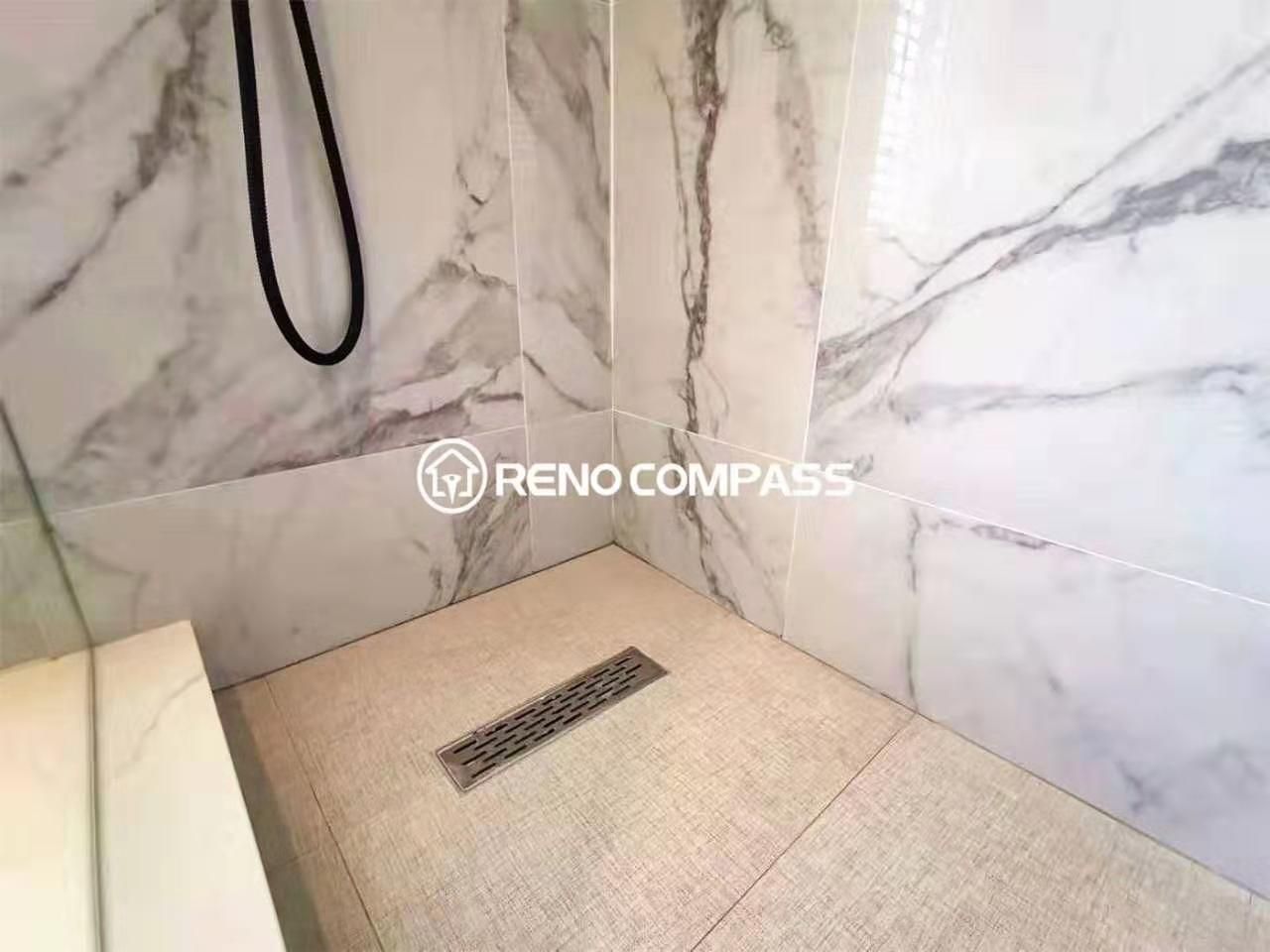 Close-up of a custom walk-in shower featuring marble-look wall tiles, a linear floor drain, and slip-resistant shower flooring. The clean tile alignment and precision installation highlight the quality workmanship of this Toronto renovation company. Designed for efficient drainage, waterproof durability, and a sleek modern finish, this bathroom renovation combines functionality with contemporary style for long-term performance.