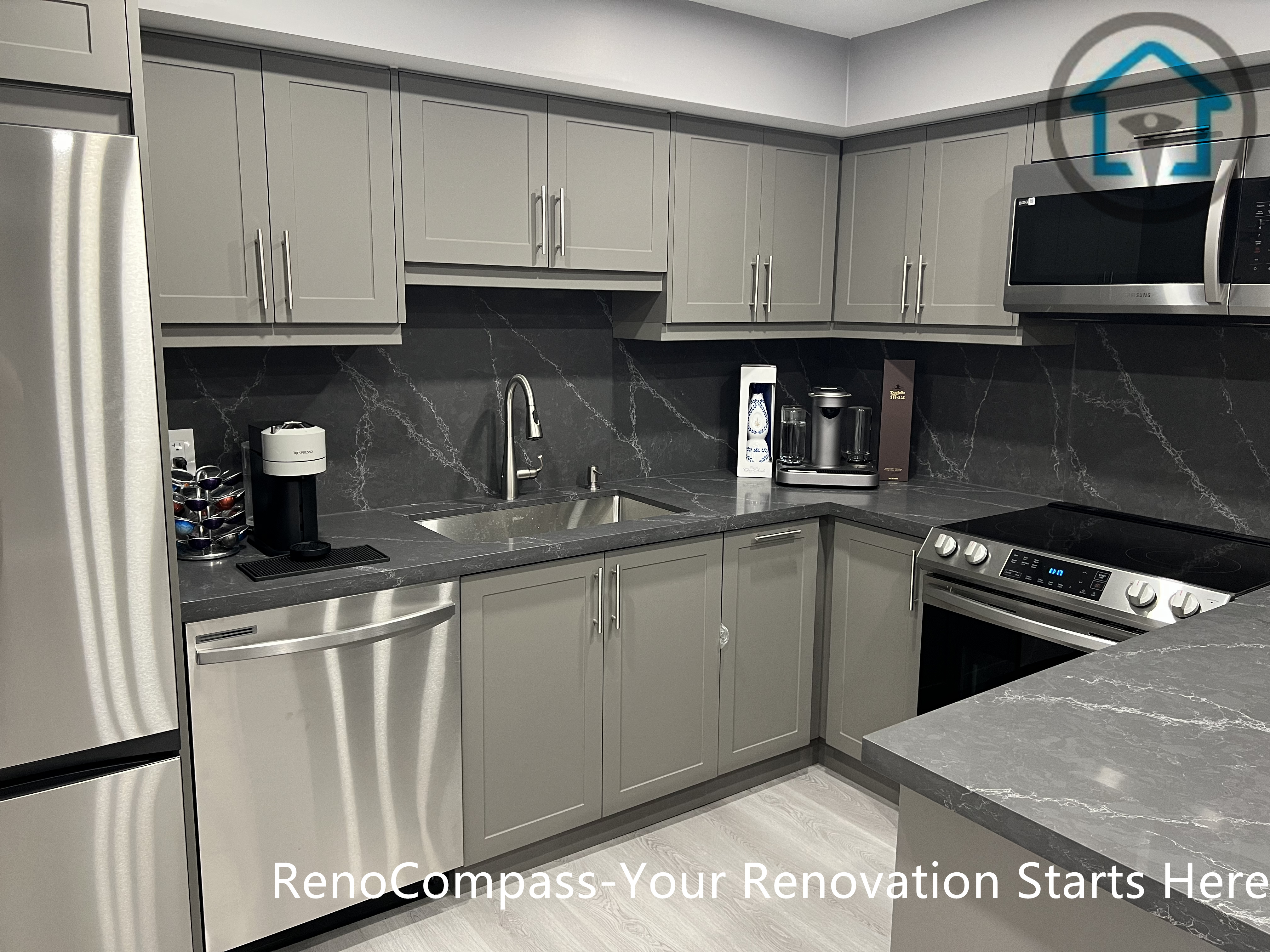This Vaughan basement renovation highlights a modern kitchen featuring custom gray cabinetry, a central island with stone-look countertop, stainless steel appliances, and recessed ceiling lighting. The functional layout maximizes storage and workspace while maintaining a clean, contemporary appearance suitable for basement living. Completed by a Toronto renovation company, this basement kitchen renovation demonstrates practical design, durable materials, and efficient use of space.