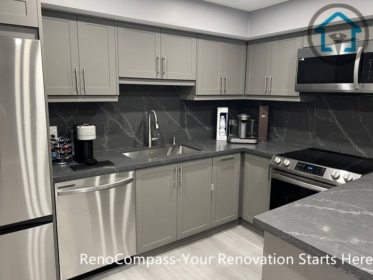 This Vaughan basement renovation highlights a modern kitchen featuring custom gray cabinetry, a central island with stone-look countertop, stainless steel appliances, and recessed ceiling lighting. The functional layout maximizes storage and workspace while maintaining a clean, contemporary appearance suitable for basement living. Completed by a Toronto renovation company, this basement kitchen renovation demonstrates practical design, durable materials, and efficient use of space.