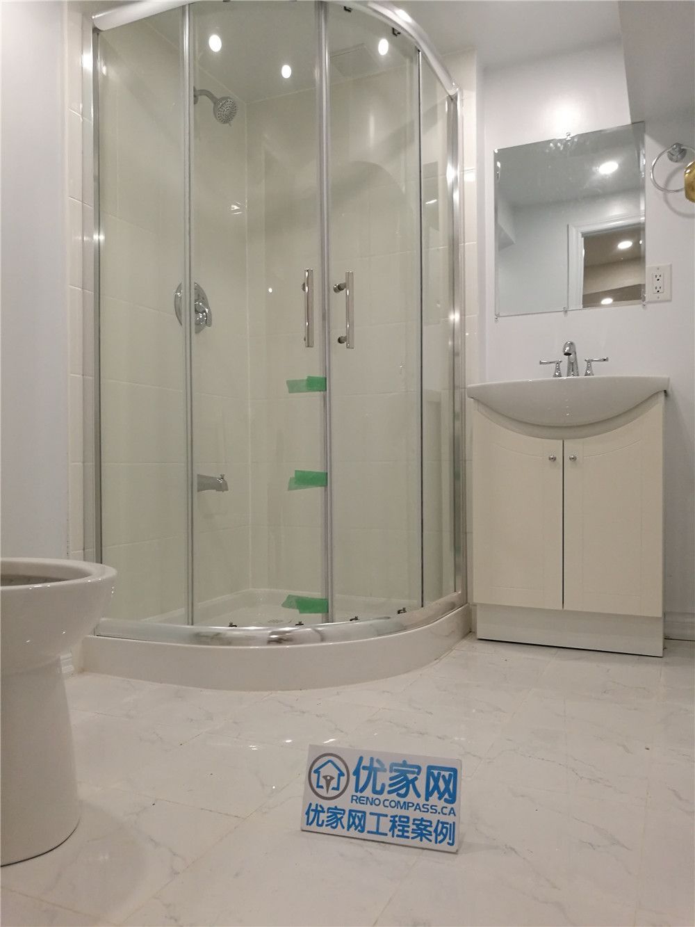 his image showcases a newly completed basement bathroom renovation in Markham. The space features a modern curved glass shower enclosure paired with sleek chrome fixtures, creating a bright and contemporary look. Light marble-style flooring enhances the sense of space while improving durability and moisture resistance. A compact vanity with integrated storage maximizes functionality, making the bathroom ideal for guest use or basement living areas. Completed by a professional Toronto Renovation Company, this project highlights quality waterproofing, efficient layout design, and clean modern finishes for long-lasting performance.