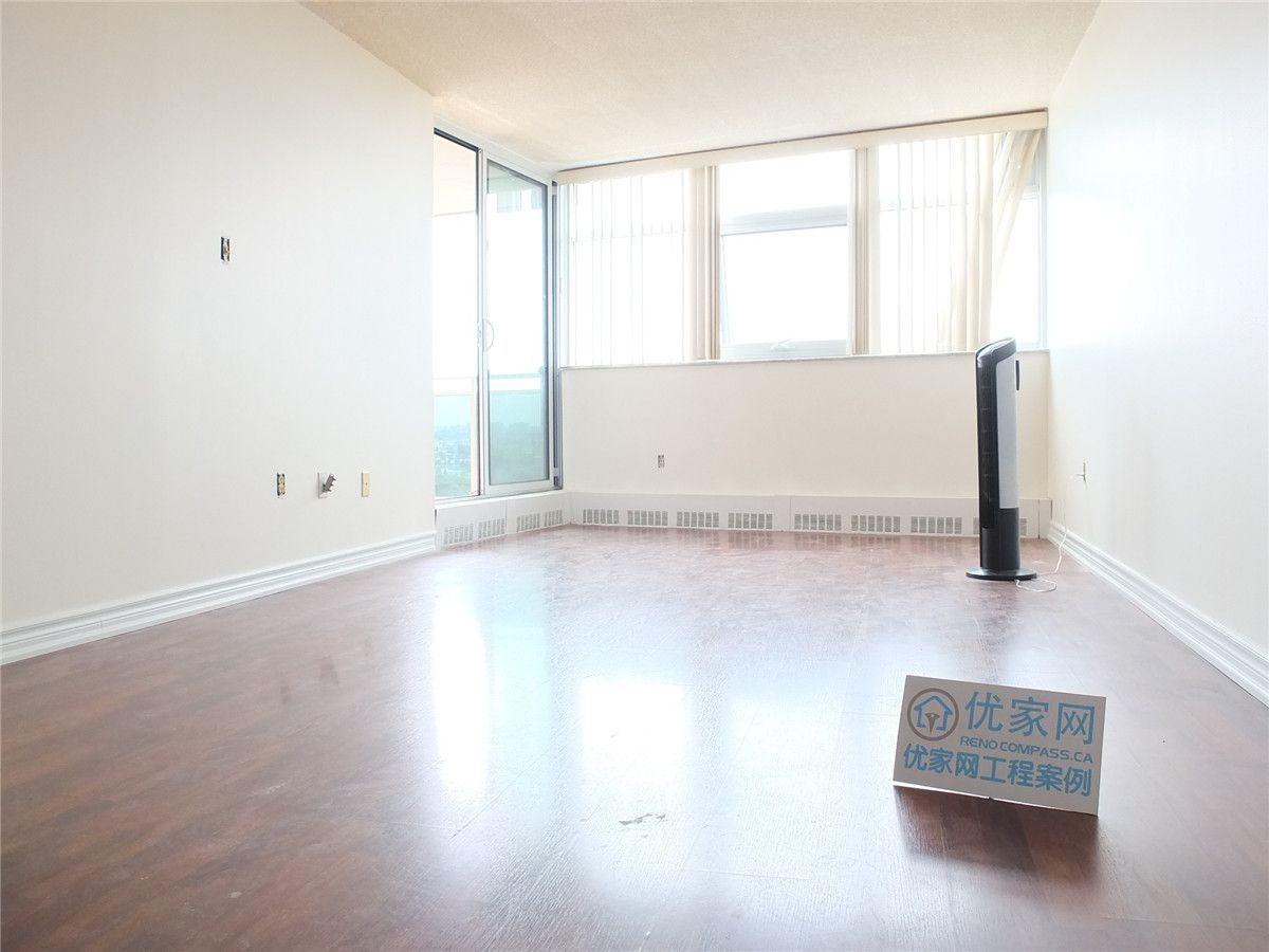 A bright and refreshed condo interior in Scarborough featuring newly installed flooring and clean white walls. This open living space benefits from large windows that enhance natural light, creating a warm and comfortable atmosphere. The renovation improves overall functionality and visual appeal, showcasing professional interior renovation work by a Toronto renovation company.