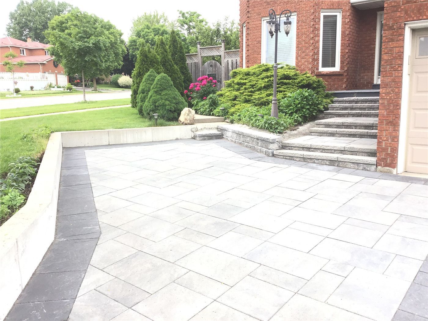 This Mississauga landscaping renovation features a professionally installed interlocking driveway with a modern grey tone and clean border design. The project enhances curb appeal while ensuring durability, proper drainage, and long-term low maintenance.