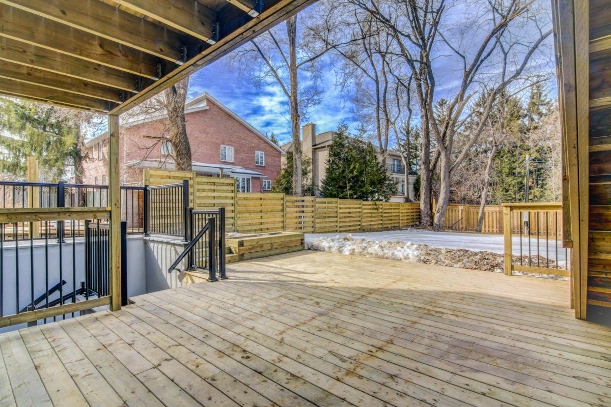 Spacious backyard deck renovation in Toronto featuring a large natural wood patio, modern fencing, and stair access to the lower level. The outdoor space is designed for relaxation and entertainment, offering durable materials and a clean contemporary layout. Completed by a professional Toronto renovation company, this backyard renovation enhances both property value and everyday outdoor living.