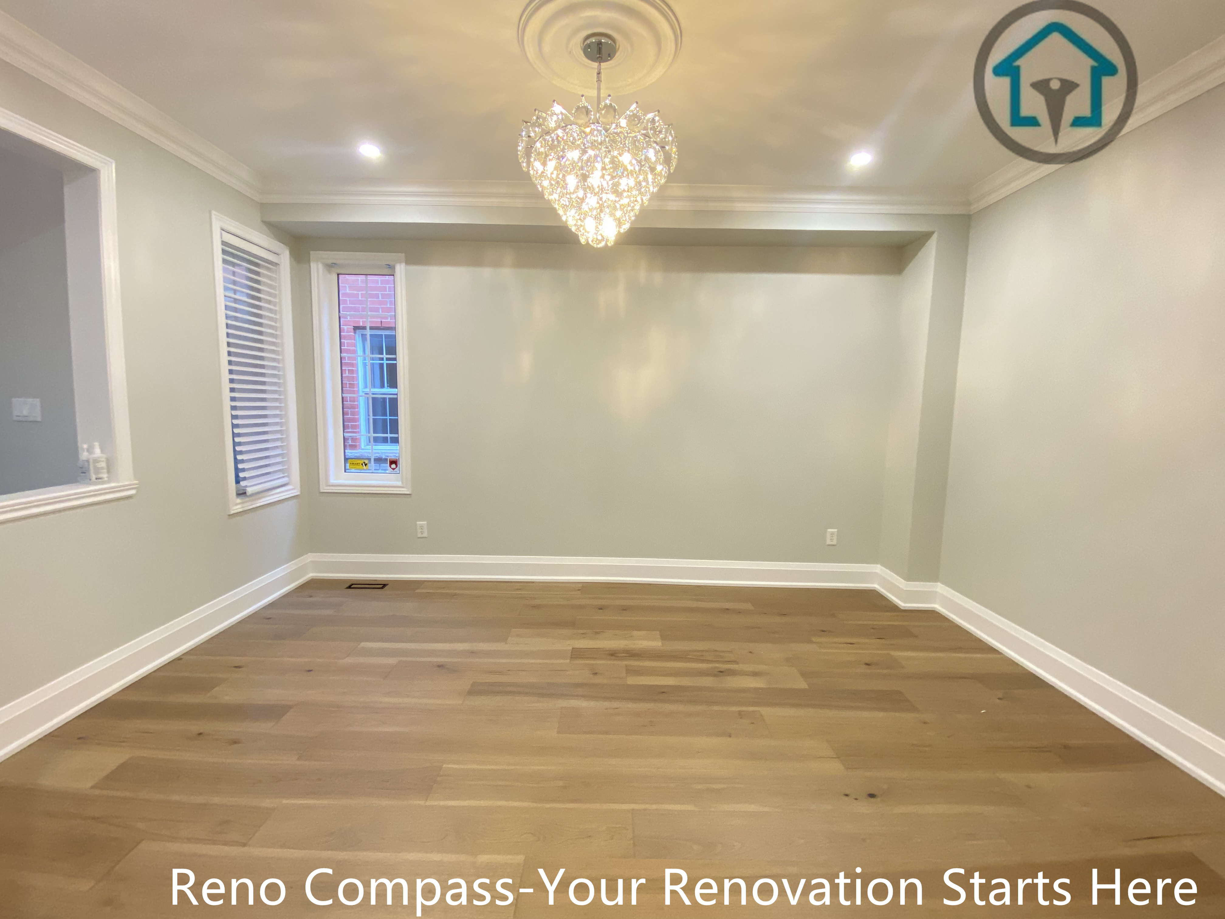 This image presents a spacious living area completed as part of a hardwood flooring renovation project in Richmond Hill. The room features wide-plank hardwood flooring, soft neutral wall tones, and refined trim details that enhance the overall sense of balance and openness. A modern chandelier and recessed lighting add warmth and visual interest while maintaining a clean, contemporary look. Completed by a professional Toronto renovation company, this renovation emphasizes material quality, natural light, and a timeless interior finish designed for everyday living.