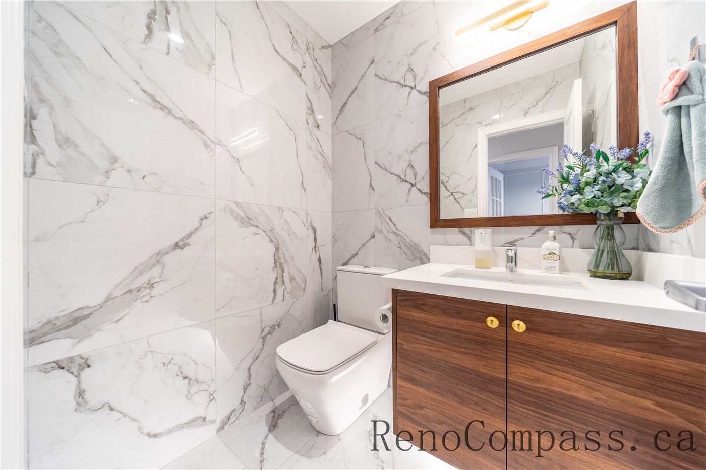 This Richmond Hill entire house interior renovation features a modern bathroom upgrade with large-format marble-style wall tiles, a custom wood vanity, and sleek contemporary fixtures. Clean lines, warm finishes, and elegant lighting create a bright and sophisticated space designed for comfort and durability. Completed by a trusted Toronto renovation company, this bathroom renovation blends luxury aesthetics with practical functionality for everyday living.