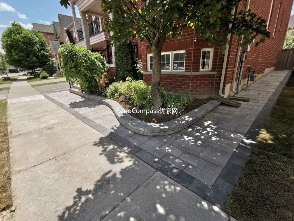 Side walkway installation in Richmond Hill with interlocking gray stones and a raised garden edge. This clean, contemporary design complements the home’s landscape while improving functionality and drainage.