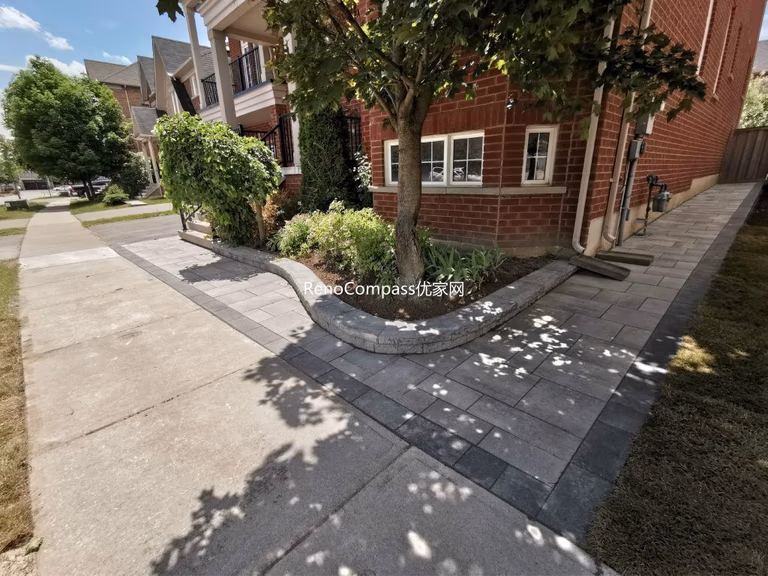 Side walkway installation in Richmond Hill with interlocking gray stones and a raised garden edge. This clean, contemporary design complements the home’s landscape while improving functionality and drainage.