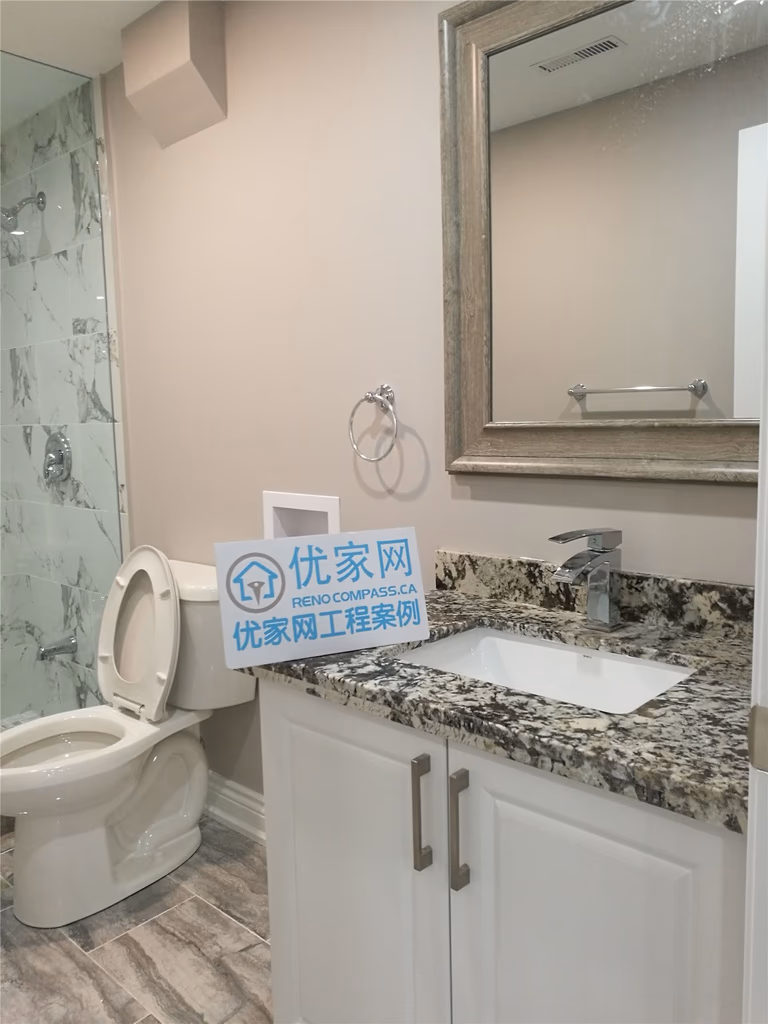 Basement bathroom renovation in Richmond Hill showcasing a custom vanity with granite countertop, modern sink and faucet, updated toilet installation, and neutral wall finishes. This basement bathroom remodel enhances storage, functionality, and overall comfort, completed by a professional Toronto renovation company.