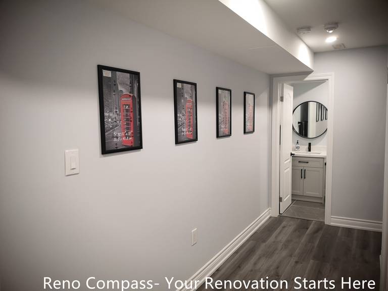 This Whitby basement renovation features a clean and well-lit hallway that connects the main basement area to the bathroom. Continuous wood-look flooring enhances visual flow, while recessed ceiling lights provide balanced illumination throughout the corridor. Minimal wall finishes and framed artwork add subtle character without overwhelming the space. The layout improves circulation and accessibility, reinforcing the functionality and comfort of the finished basement design.