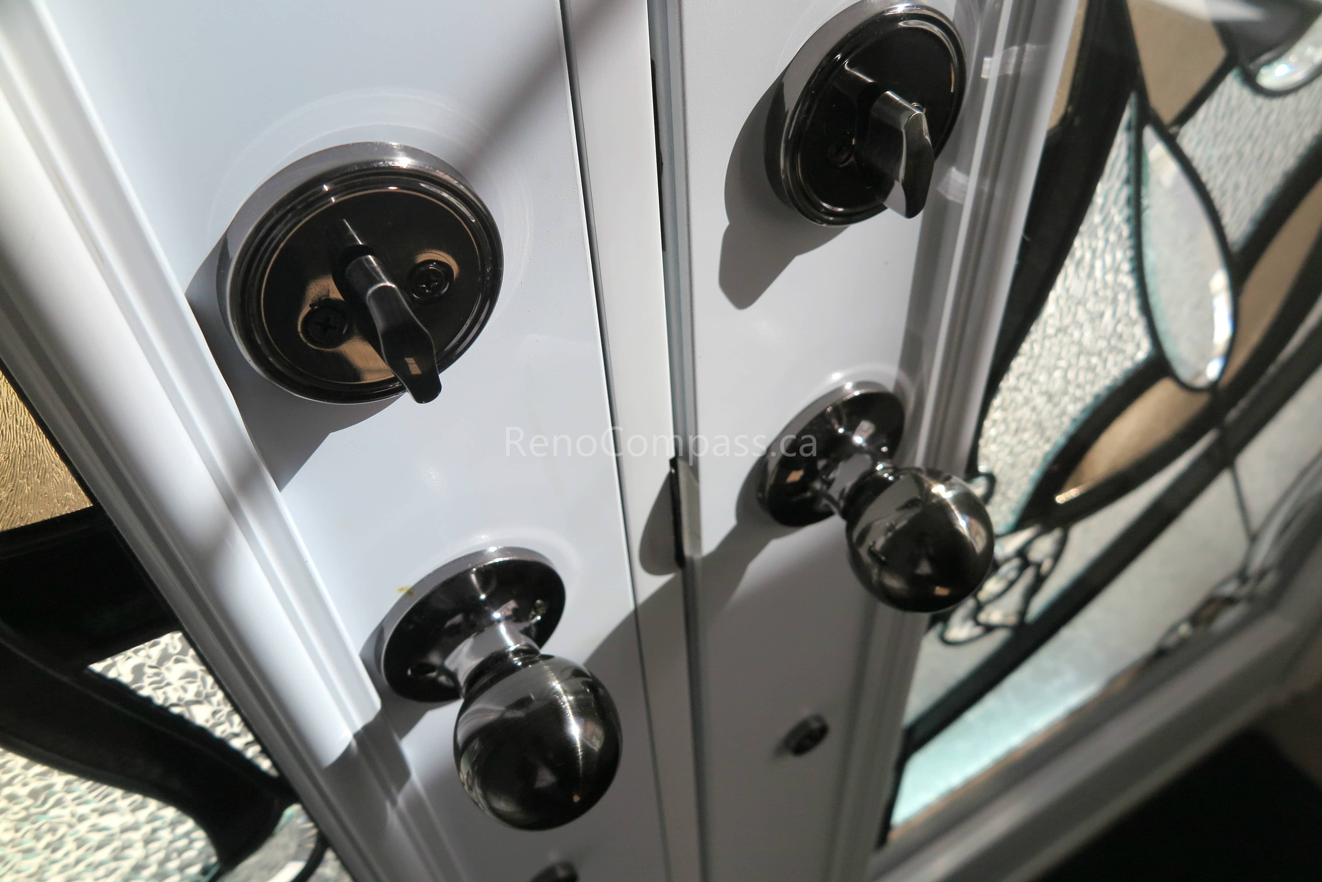 Close-up detail of newly installed double entry door hardware in a Newmarket home, featuring modern black handles and secure locking systems paired with decorative privacy glass panels. Completed by a professional Toronto Renovation Company, this door upgrade enhances both security and visual appeal while adding a refined, high-end finish to the home’s main entrance.