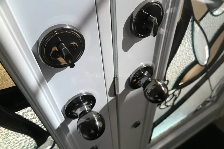 Close-up detail of newly installed double entry door hardware in a Newmarket home, featuring modern black handles and secure locking systems paired with decorative privacy glass panels. Completed by a professional Toronto Renovation Company, this door upgrade enhances both security and visual appeal while adding a refined, high-end finish to the home’s main entrance.