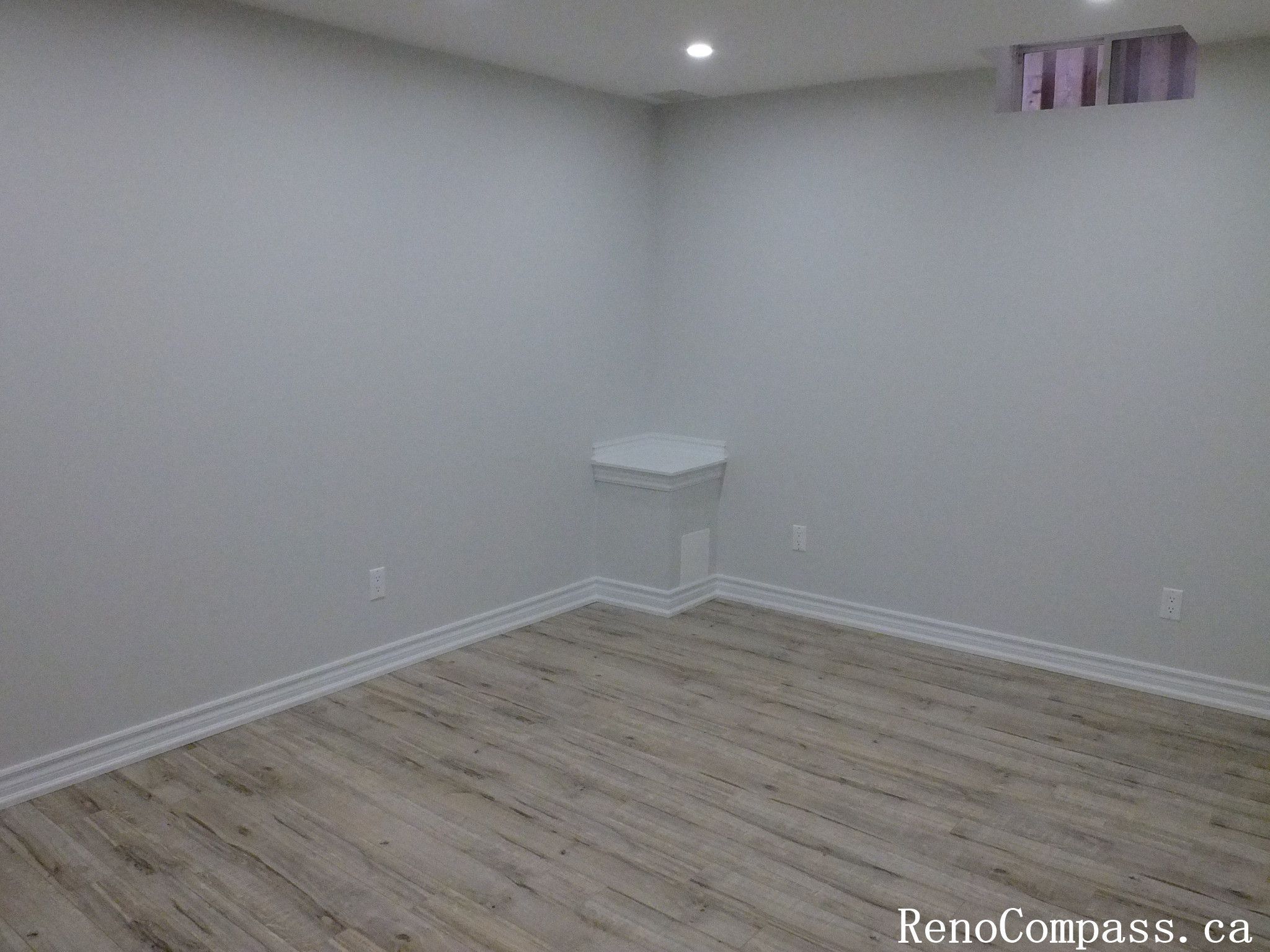 Spacious finished basement in Richmond Hill featuring bright recessed lighting, neutral paint, and crisp baseboards for a clean, modern living space by RenoCompass.ca.