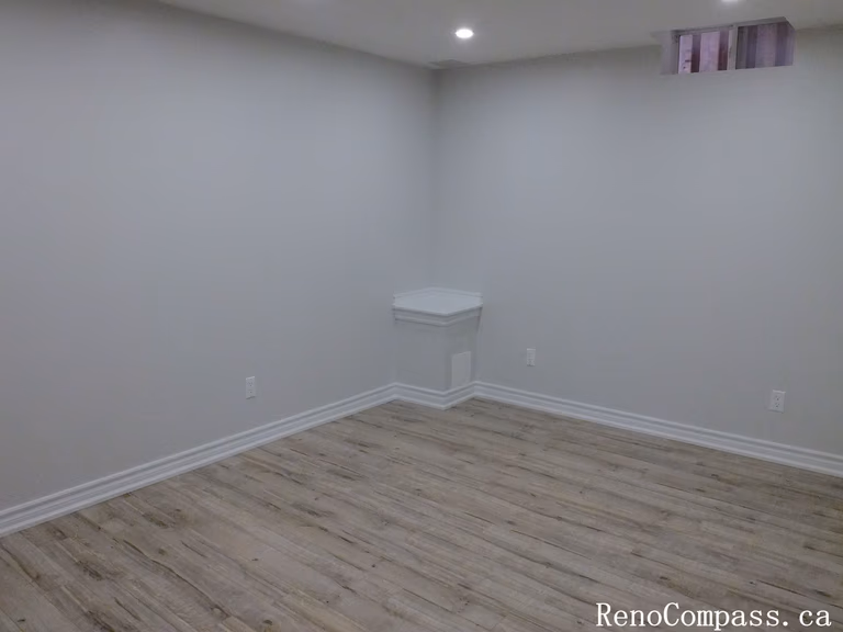 Spacious finished basement in Richmond Hill featuring bright recessed lighting, neutral paint, and crisp baseboards for a clean, modern living space by RenoCompass.ca.