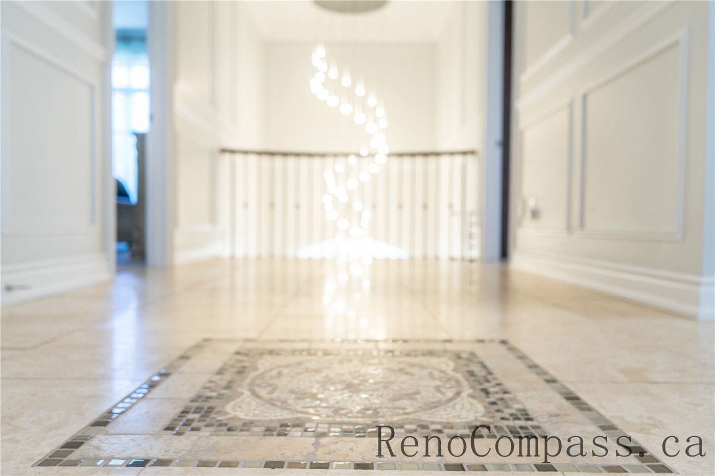 This Richmond Hill foyer renovation features custom mosaic tile flooring, elegant wall paneling, and a bright open staircase highlighted by modern lighting. The refined entrance design enhances the home’s first impression while showcasing detailed craftsmanship and premium finishes by a trusted Toronto renovation company specializing in complete interior renovations.