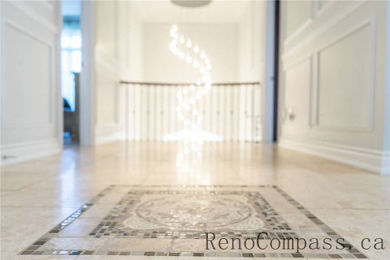 This Richmond Hill foyer renovation features custom mosaic tile flooring, elegant wall paneling, and a bright open staircase highlighted by modern lighting. The refined entrance design enhances the home’s first impression while showcasing detailed craftsmanship and premium finishes by a trusted Toronto renovation company specializing in complete interior renovations.