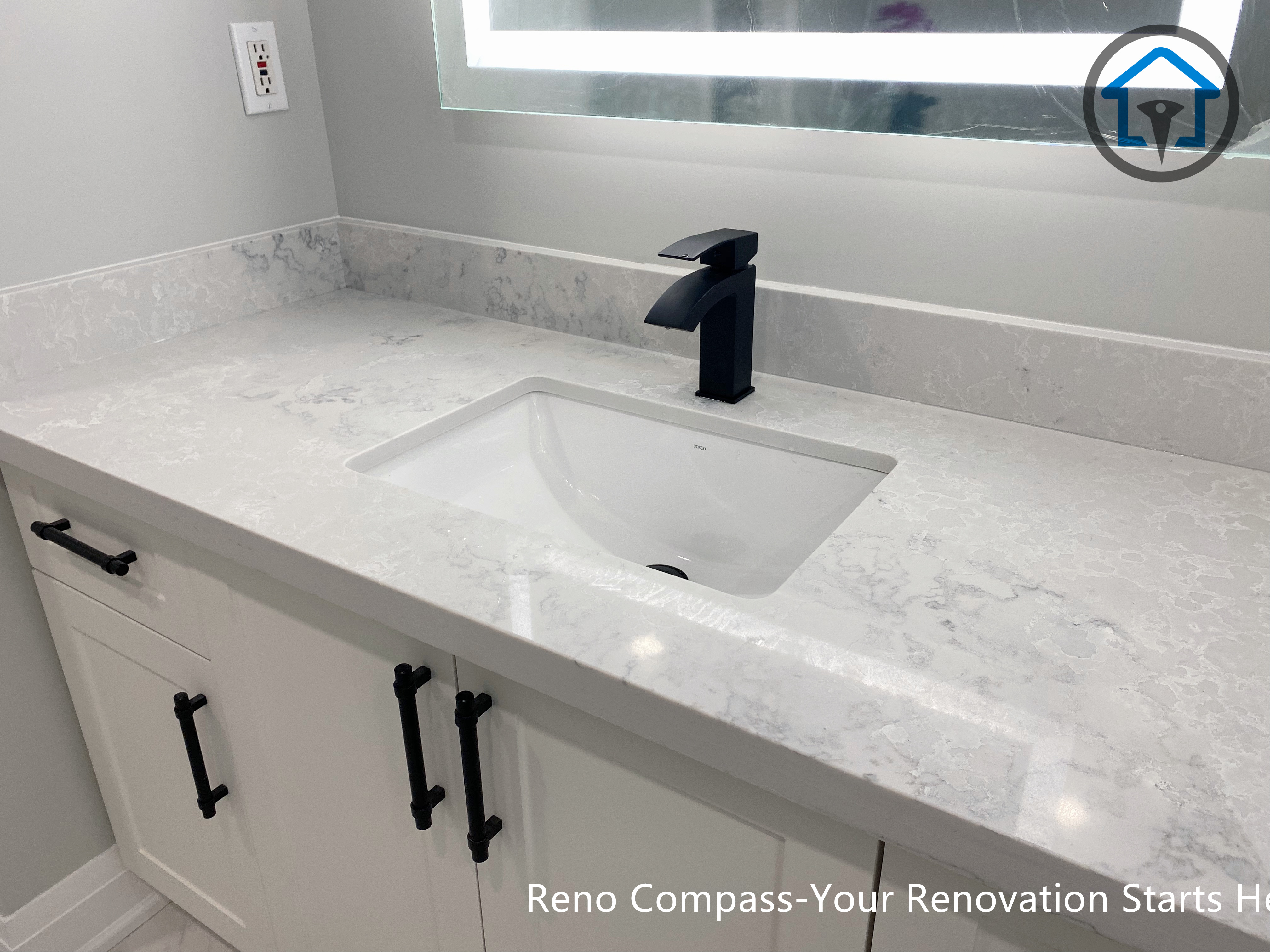 Vanity and mirror area in a Newmarket bathroom renovation featuring a painted MDF vanity, Vicostone quartz countertop, and soft lighting for a warm, welcoming feel.