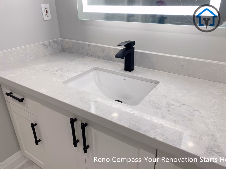 Vanity and mirror area in a Newmarket bathroom renovation featuring a painted MDF vanity, Vicostone quartz countertop, and soft lighting for a warm, welcoming feel.