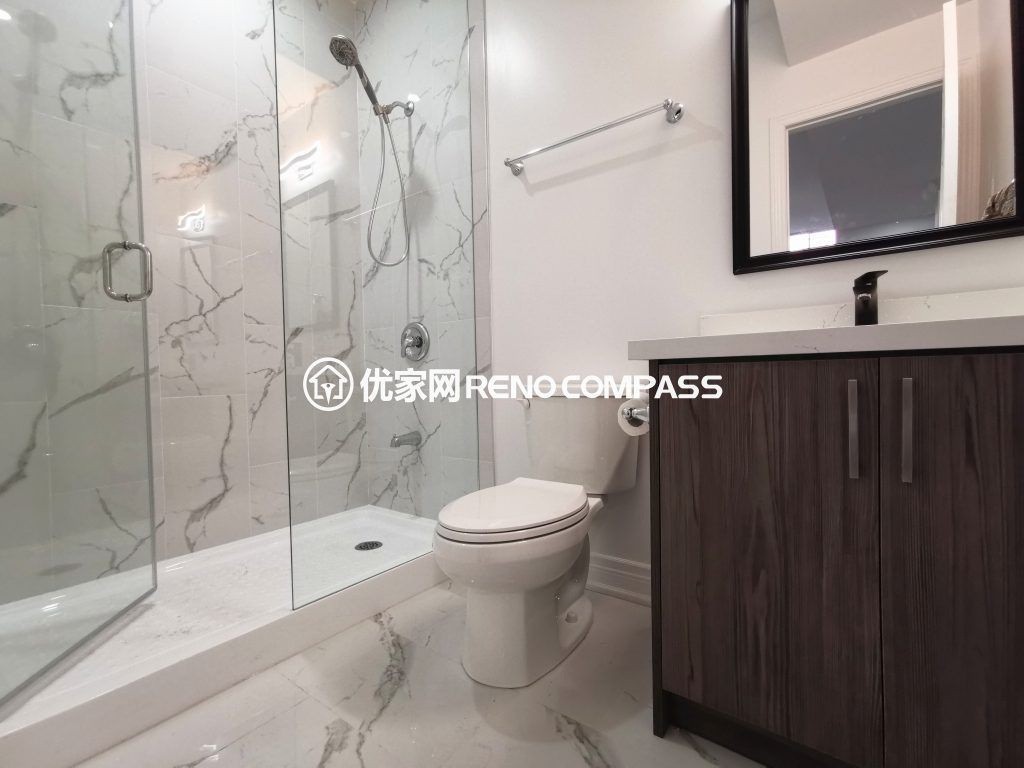 This Vaughan basement bathroom renovation features a modern glass shower enclosure with marble-style wall tiles, upgraded vanity, and contemporary fixtures. The clean layout and durable finishes create a bright, functional, and stylish bathroom designed for everyday comfort. Completed by a professional Toronto renovation company, this basement bathroom upgrade enhances both practicality and home value with quality craftsmanship and modern design.