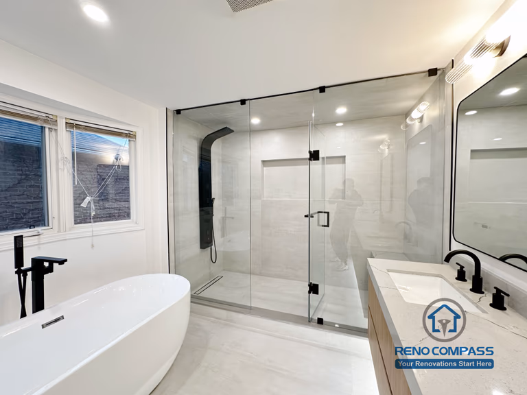 Completed Oakville bathroom renovation featuring a freestanding bathtub, frameless glass shower enclosure, custom vanity, and modern fixtures, completed by a professional Toronto renovation company.