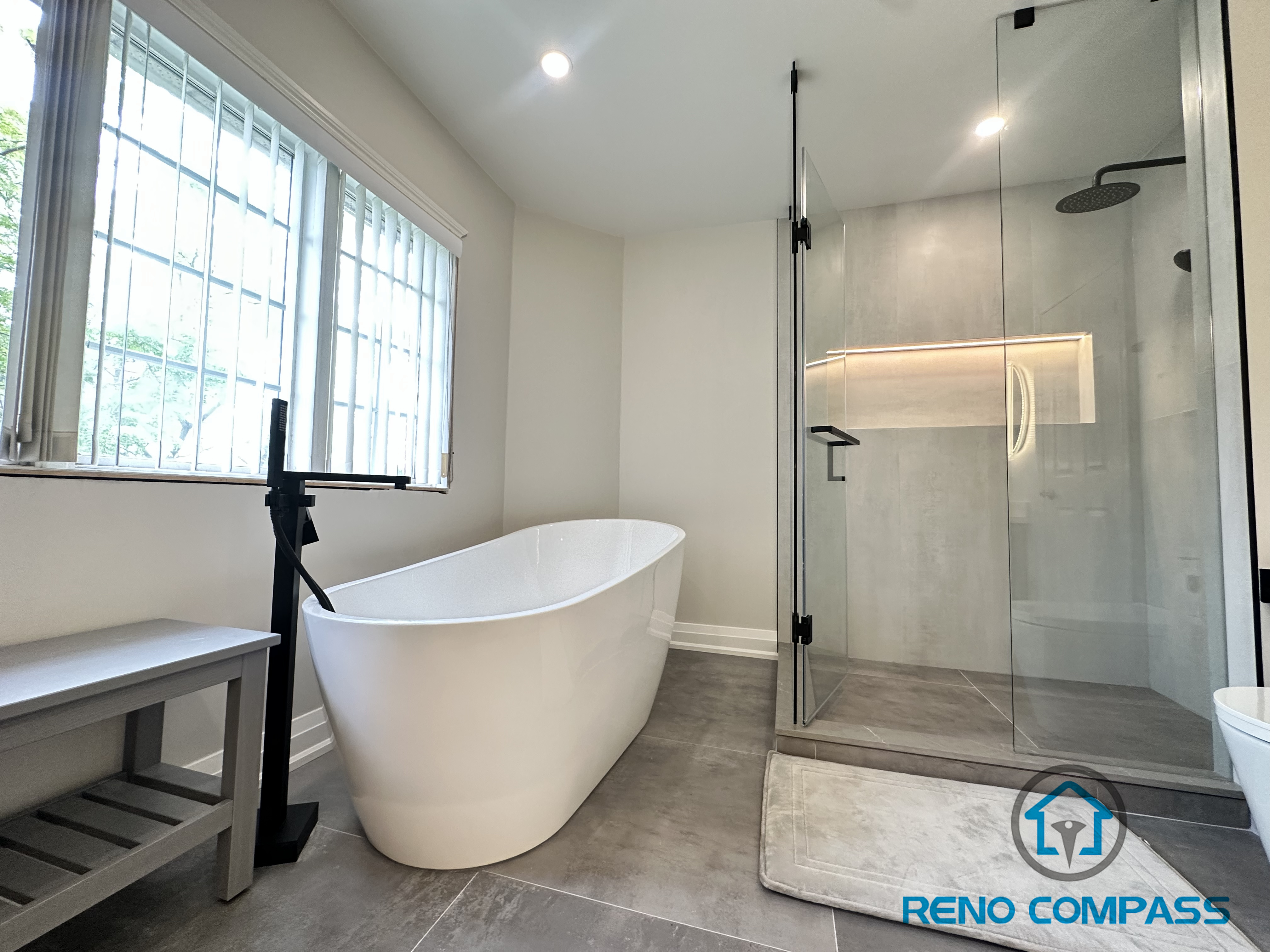 A luxurious Oakville bathroom featuring a spacious walk-in shower with frameless glass and a built-in niche, paired with a freestanding bathtub. This layout balances open design with functional storage, creating a spa-like retreat perfect for relaxation and everyday use.