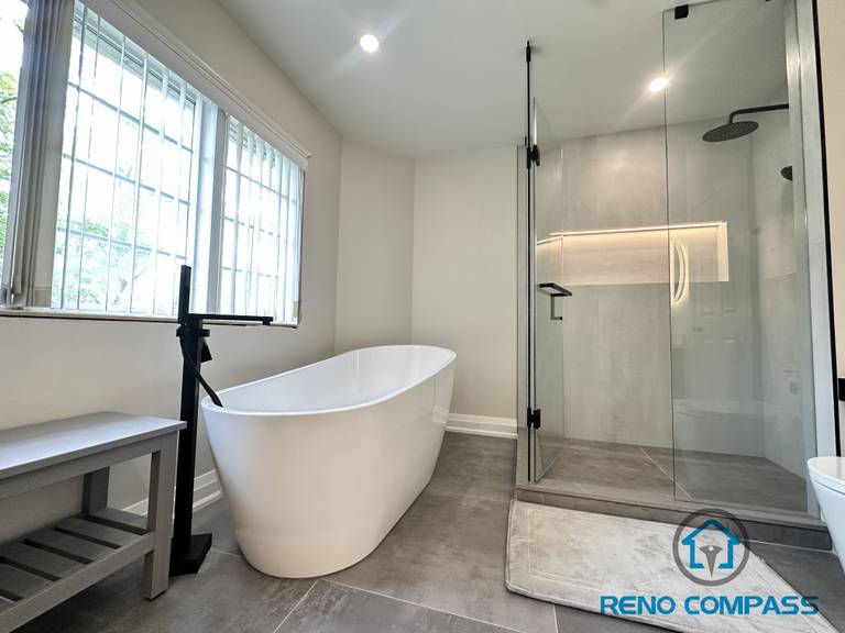 A luxurious Oakville bathroom featuring a spacious walk-in shower with frameless glass and a built-in niche, paired with a freestanding bathtub. This layout balances open design with functional storage, creating a spa-like retreat perfect for relaxation and everyday use.