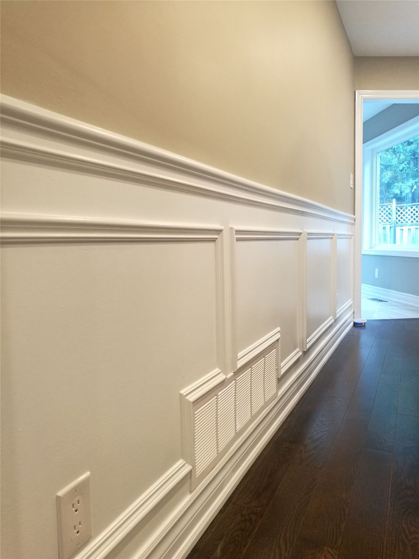 This Newmarket interior renovation features custom wall paneling and wainscoting with clean trim lines and precise detailing. Paired with dark hardwood flooring, the refined wall finish adds depth and elegance to the space, highlighting the craftsmanship and finish quality delivered by a professional Toronto renovation company.