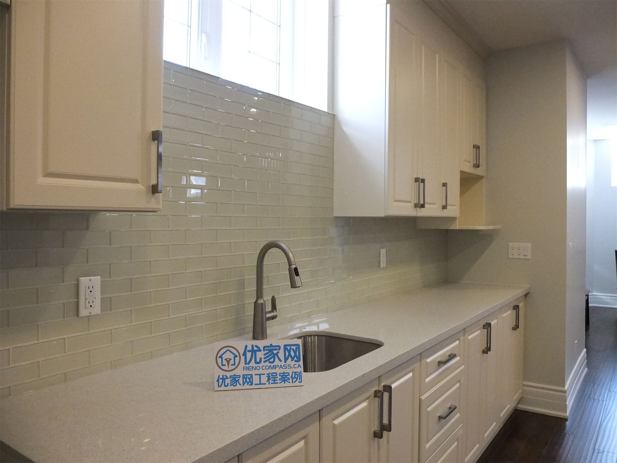 This Richmond Hill basement renovation includes a beautifully finished kitchen area featuring custom cream cabinetry, quartz countertops, and a modern tile backsplash. The space is designed with ample storage, a functional sink station, and clean upper and lower cabinets for a sleek and organized look. Bright basement windows and neutral finishes enhance the overall atmosphere, creating a practical and stylish secondary kitchen ideal for rental or multi-generational living.