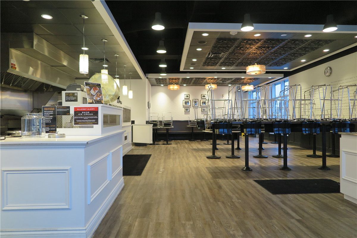 This Toronto restaurant renovation highlights the upgraded front service counter and customer-facing area completed by Reno Compass Inc. The project included custom-built cashier counters, integrated POS stations, decorative ceiling bulkheads with recessed lighting, and commercial-grade pendant fixtures to enhance ambiance and visibility.

The open layout improves customer flow and ordering efficiency, while durable vinyl flooring ensures long-term performance in high-traffic commercial environments. The refined white counter millwork contrasts with the modern dark ceiling design, creating a clean yet contemporary restaurant atmosphere.

As an experienced Toronto renovation company, Reno Compass Inc. specializes in restaurant interior renovations that balance operational functionality with strong visual branding.