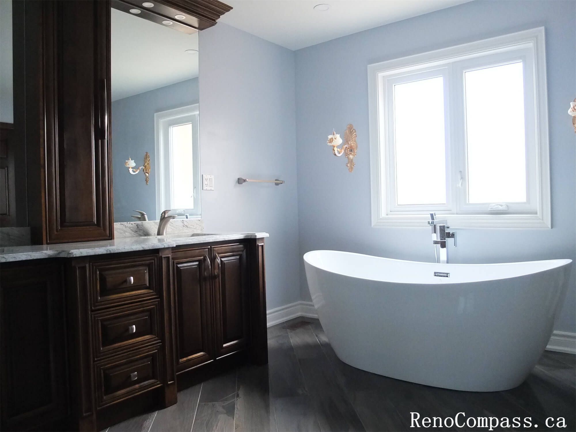 This Richmond Hill interior renovation showcases a modern luxury bathroom featuring a frameless glass walk-in shower, marble-style wall tiles, and custom solid wood vanity cabinetry with quartz countertops. The spacious layout improves functionality while maintaining an elegant and timeless design. Large mirrors, upgraded lighting, and durable floor tiles enhance both comfort and usability for daily living. Completed by a professional Toronto renovation company, this bathroom renovation combines high-end finishes with practical design to increase home value and long-term performance.