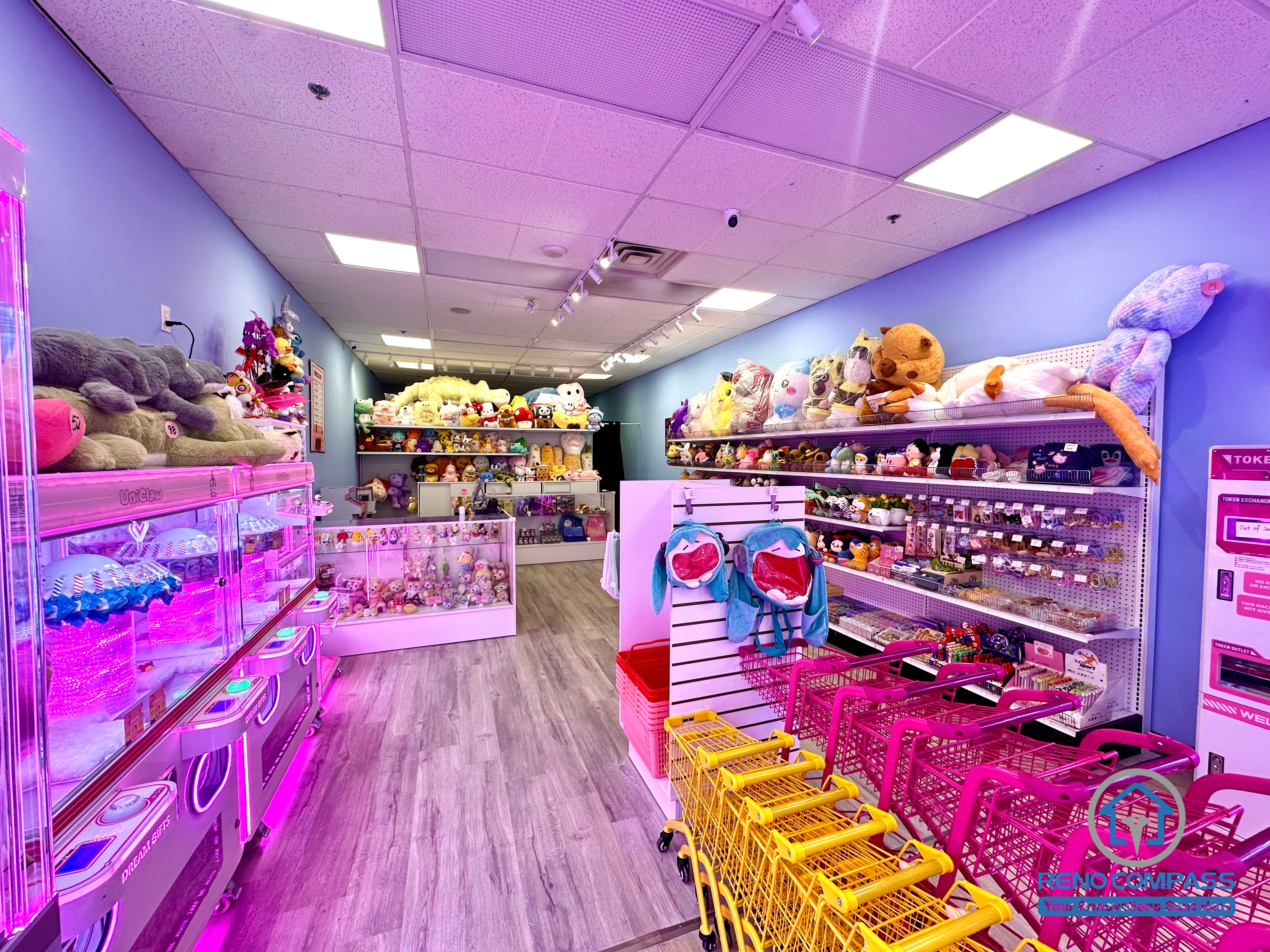 Prize display shelves and checkout counter inside an arcade claw machine store at Oakville Place Mall. The layout combines arcade gaming machines with retail prize displays, creating an indoor playground-style entertainment environment for visitors.