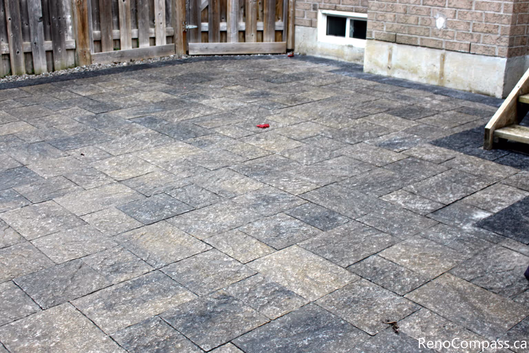 This Markham backyard landscaping project features a spacious interlocking stone patio seamlessly connected to a raised wooden deck. The clean paving layout creates a functional outdoor living area suitable for dining, relaxation, and year-round use. Completed by a Toronto renovation company, the interlocking patio enhances durability, drainage performance, and the overall usability of the backyard space.