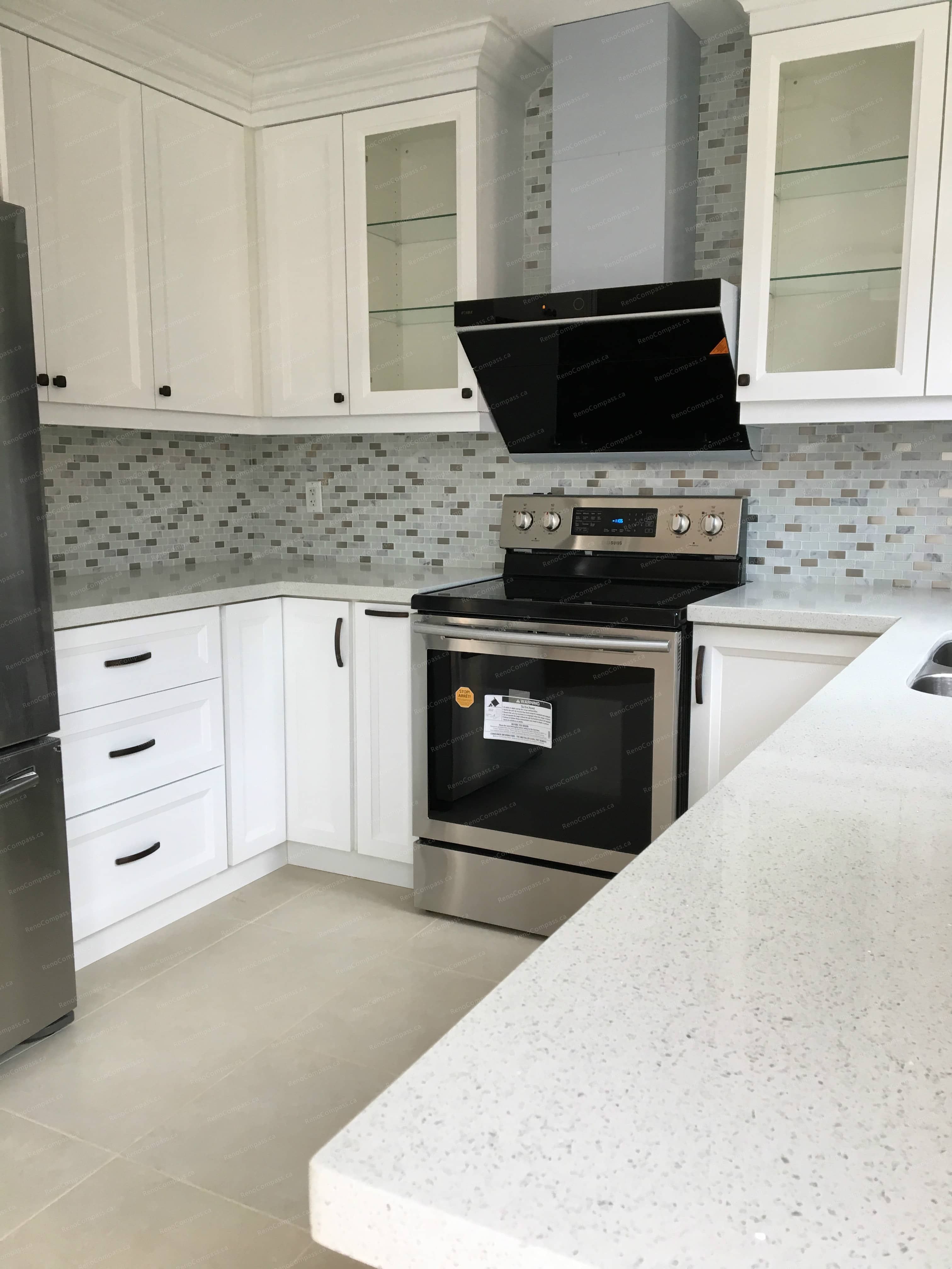 This Markham interior renovation features a bright modern kitchen upgrade with white shaker cabinets, quartz countertops, stainless steel appliances, and contemporary backsplash tile. Completed by a professional Toronto renovation company, the space was redesigned to improve functionality, storage, and overall flow while maintaining a clean, timeless aesthetic.