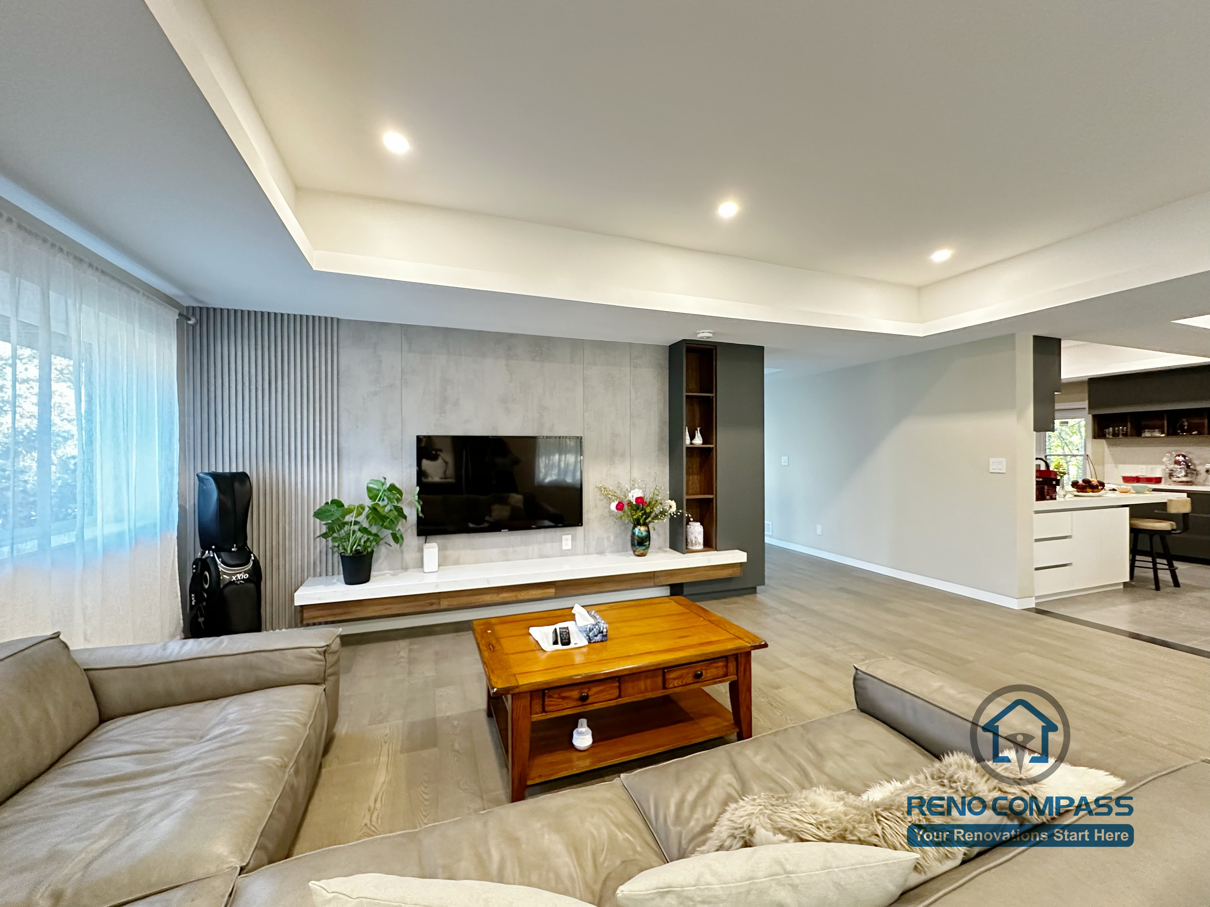 Open-concept living room completed as part of a North York interior renovation. This view highlights the seamless connection between the living area and adjacent spaces, featuring recessed ceiling lighting, wide-plank flooring, and a custom TV wall that anchors the room. Designed for clarity, flow, and everyday comfort by a professional Toronto renovation company.