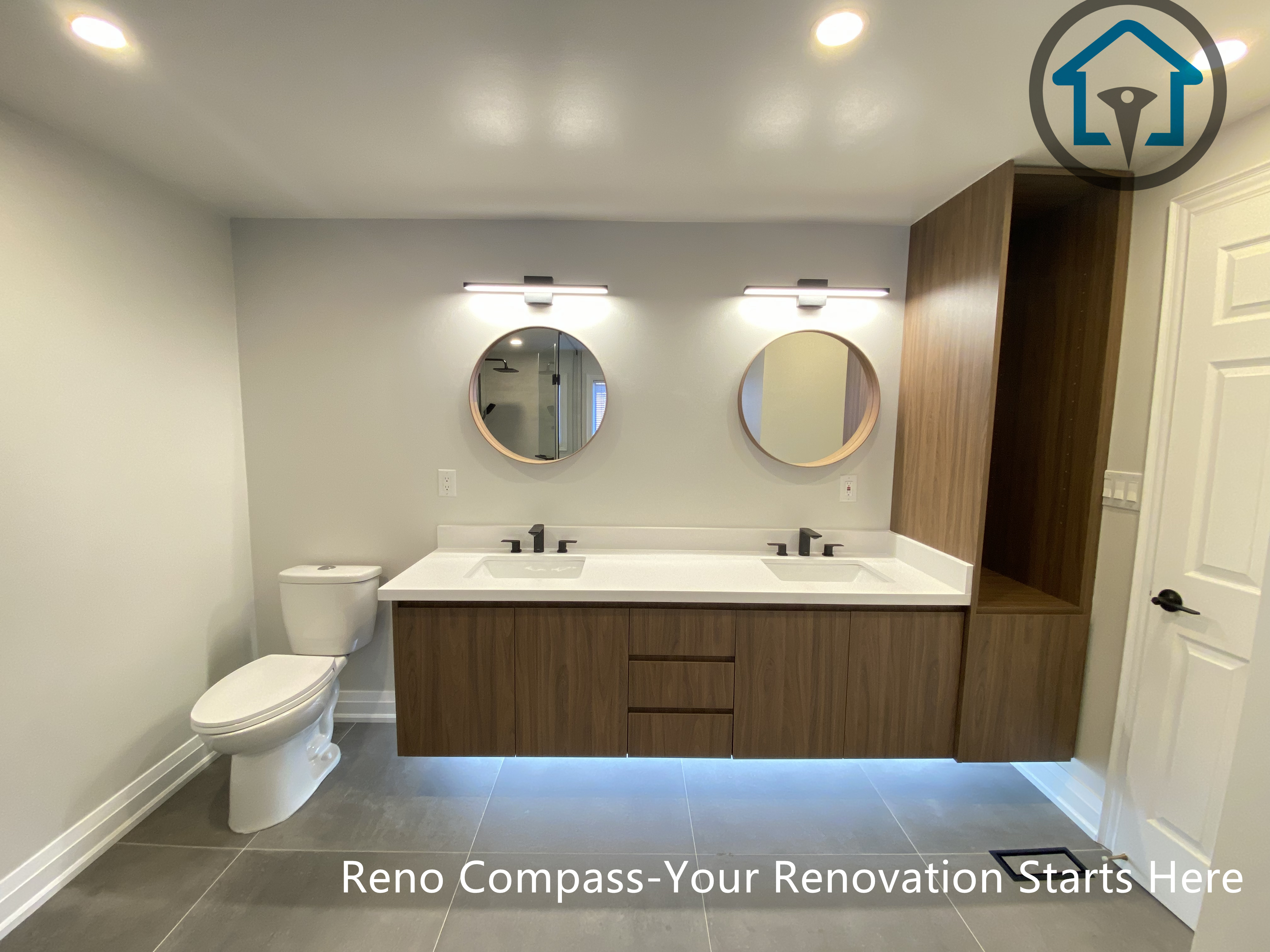 Modern bathroom renovation in Markham featuring a floating wood vanity with double sinks, round mirrors, integrated LED lighting, and a clean minimalist layout. This project showcases functional storage, soft neutral tones, and a contemporary design completed by a professional Toronto renovation company.
