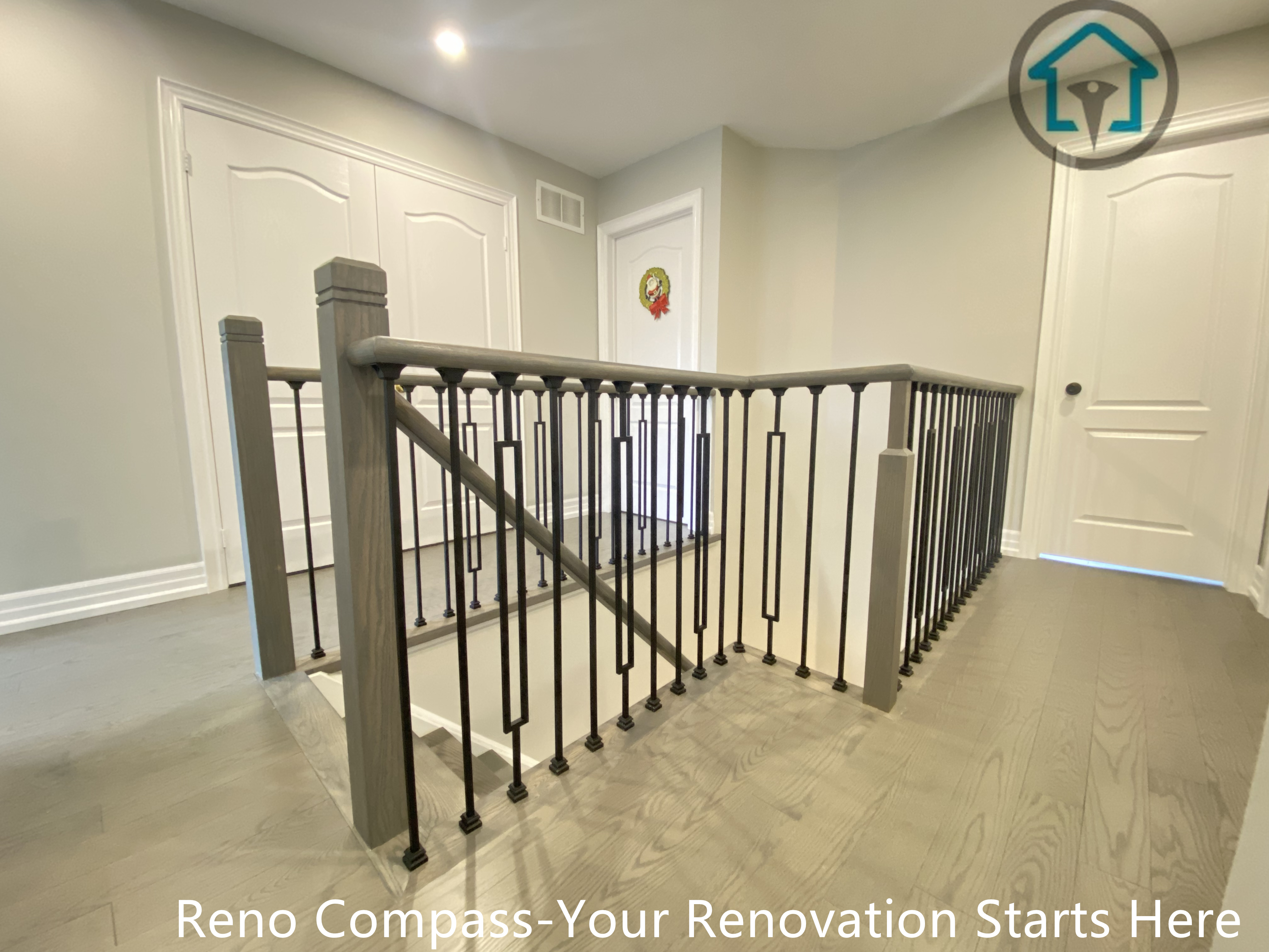 This second-floor stair landing features custom wood newel posts paired with slim black metal balusters, creating a refined balance between warmth and structure. The clean lines and consistent spacing enhance safety while maintaining visual openness across the upper level. Designed to integrate seamlessly with the surrounding flooring and interior finishes, the guardrail adds continuity and architectural clarity to the home’s overall renovation by Reno Compass.