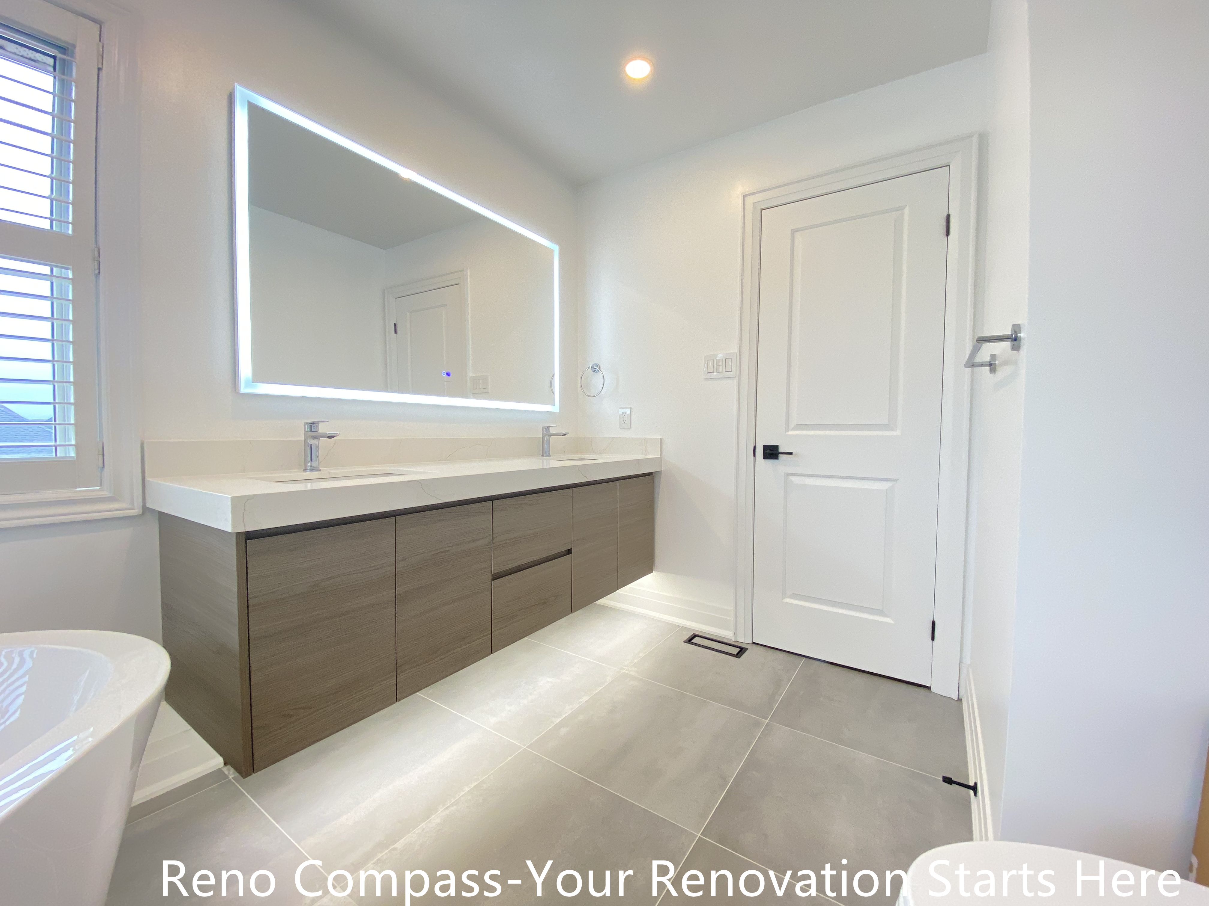 Spacious double sink bathroom vanity featured in an Oakville interior renovation, showcasing a wall-mounted wood-finish cabinet, quartz countertop, and large LED backlit mirror. The design emphasizes functionality, clean lines, and balanced lighting, delivering a modern bathroom upgrade by a professional Toronto renovation company.