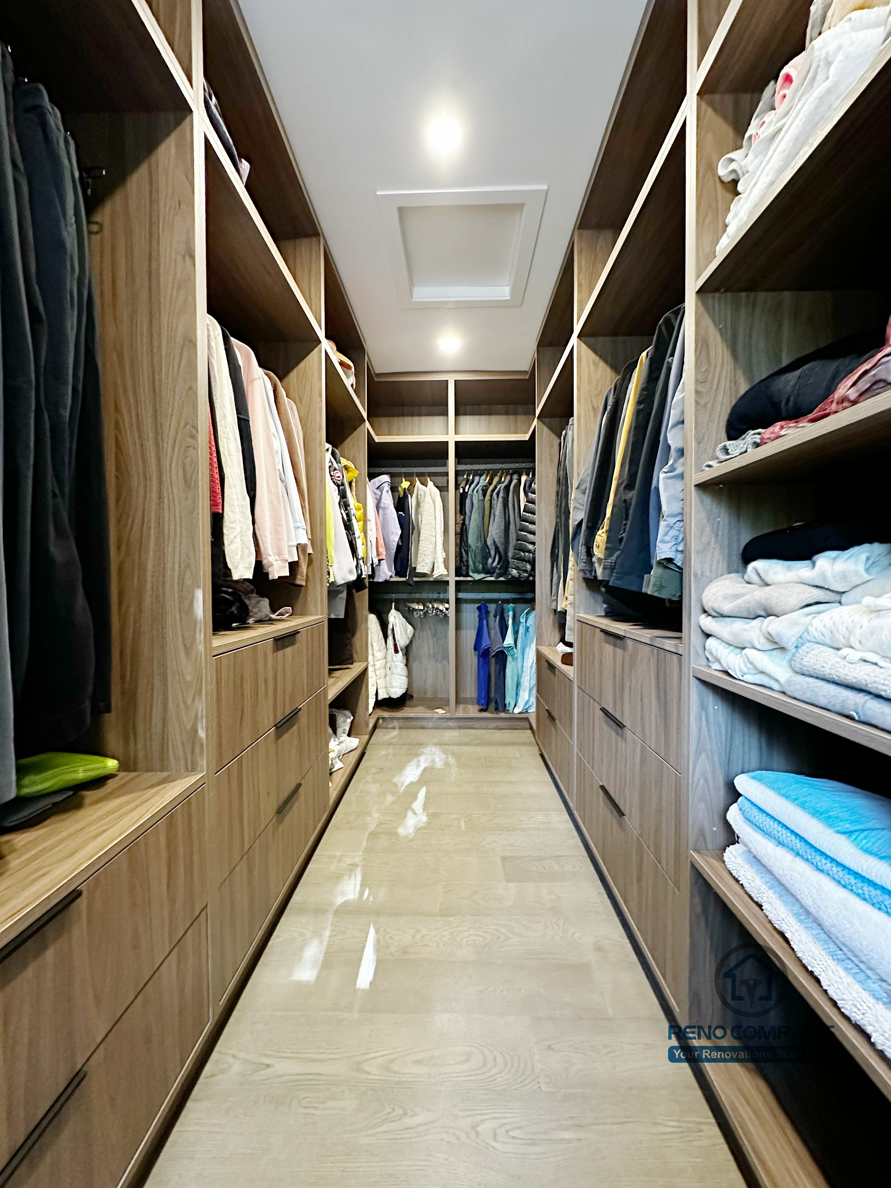 Custom walk-in closet completed as part of a North York interior renovation. This design features floor-to-ceiling wood cabinetry, integrated drawers, open shelving, and efficient space planning for everyday storage. Built by a professional Toronto renovation company with a focus on functionality, clean lines, and long-term durability.