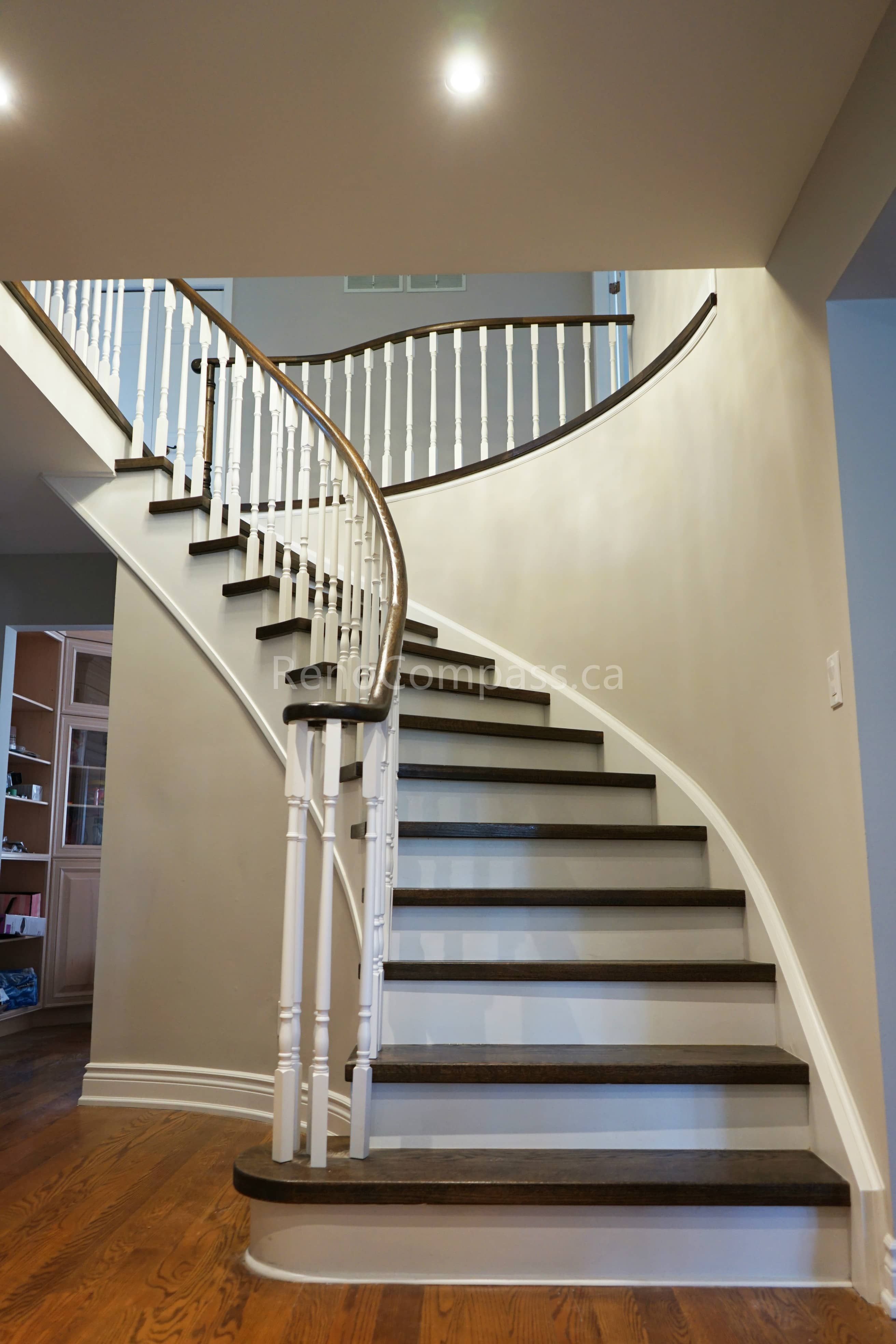 This North York interior renovation features a beautifully renovated curved staircase with hardwood treads, white risers, and classic railing details. The smooth stair geometry and refined finishes enhance both safety and visual flow within the home. Completed by a professional Toronto renovation company, this project highlights skilled stair renovation workmanship, structural precision, and high-quality interior detailing for Toronto residential homes.