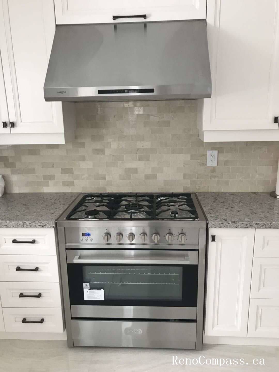 This Markham interior renovation features a modern kitchen upgrade centered around a stainless steel gas range and matching hood fan installation. The space includes custom white cabinetry with matte black hardware, a durable granite countertop, and a neutral mosaic tile backsplash that enhances texture and depth. The integrated appliance layout provides both functionality and a streamlined appearance, while the clean color palette maintains a bright and timeless design. Completed with precise cabinetry alignment and professional appliance installation, this kitchen renovation reflects Reno Compass’ commitment to quality craftsmanship and high-standard interior renovation services in Markham and the Greater Toronto Area.