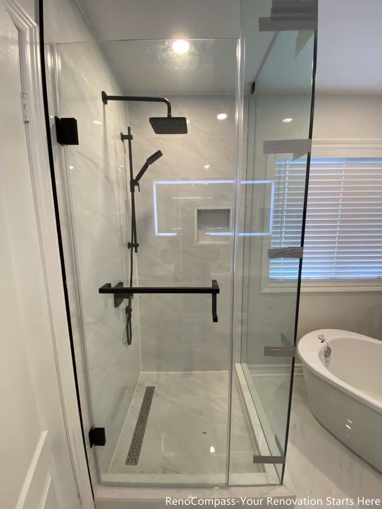 This Markham bathroom renovation highlights the walk-in shower in detail, featuring full-height marble-look wall tiles, a clear glass enclosure, and matte black shower fixtures. A linear floor drain and recessed wall niche improve drainage and daily usability while keeping the shower area clean and visually streamlined.
City: Markham · Toronto contractor: Reno Compass