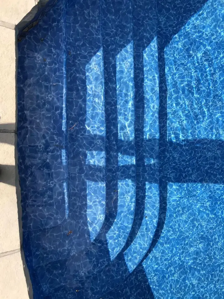 After renovation photo of a fully restored backyard swimming pool in Toronto. The new bright blue liner, clean water, and resurfaced edges highlight the professional pool transformation from old and damaged to modern and inviting. Expert pool renovation by local Toronto specialists.