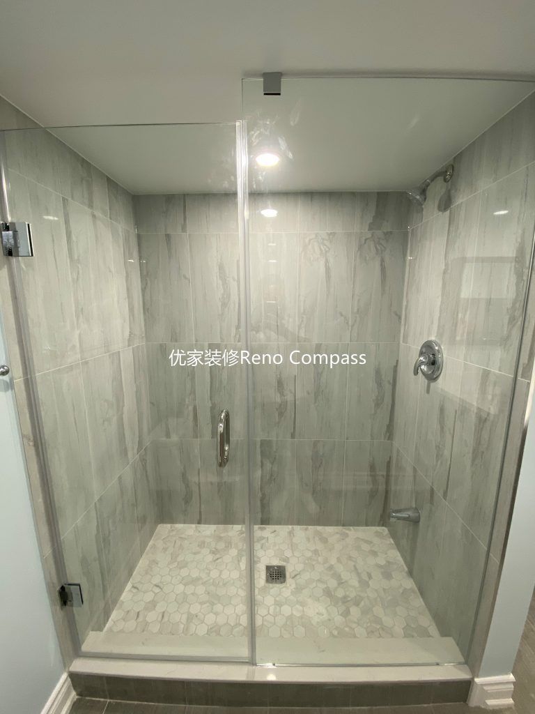 This Aurora basement renovation features a modern walk-in glass shower completed by a professional Toronto renovation company. The shower is finished with full-height marble-look wall tiles, a custom mosaic shower base, and a frameless glass enclosure that enhances both brightness and space. Precision tile installation, proper waterproofing, and clean contemporary fixtures create a durable and elegant bathroom upgrade, adding comfort, functionality, and long-term value to the basement living space. Contractor: Reno Compass Inc.
