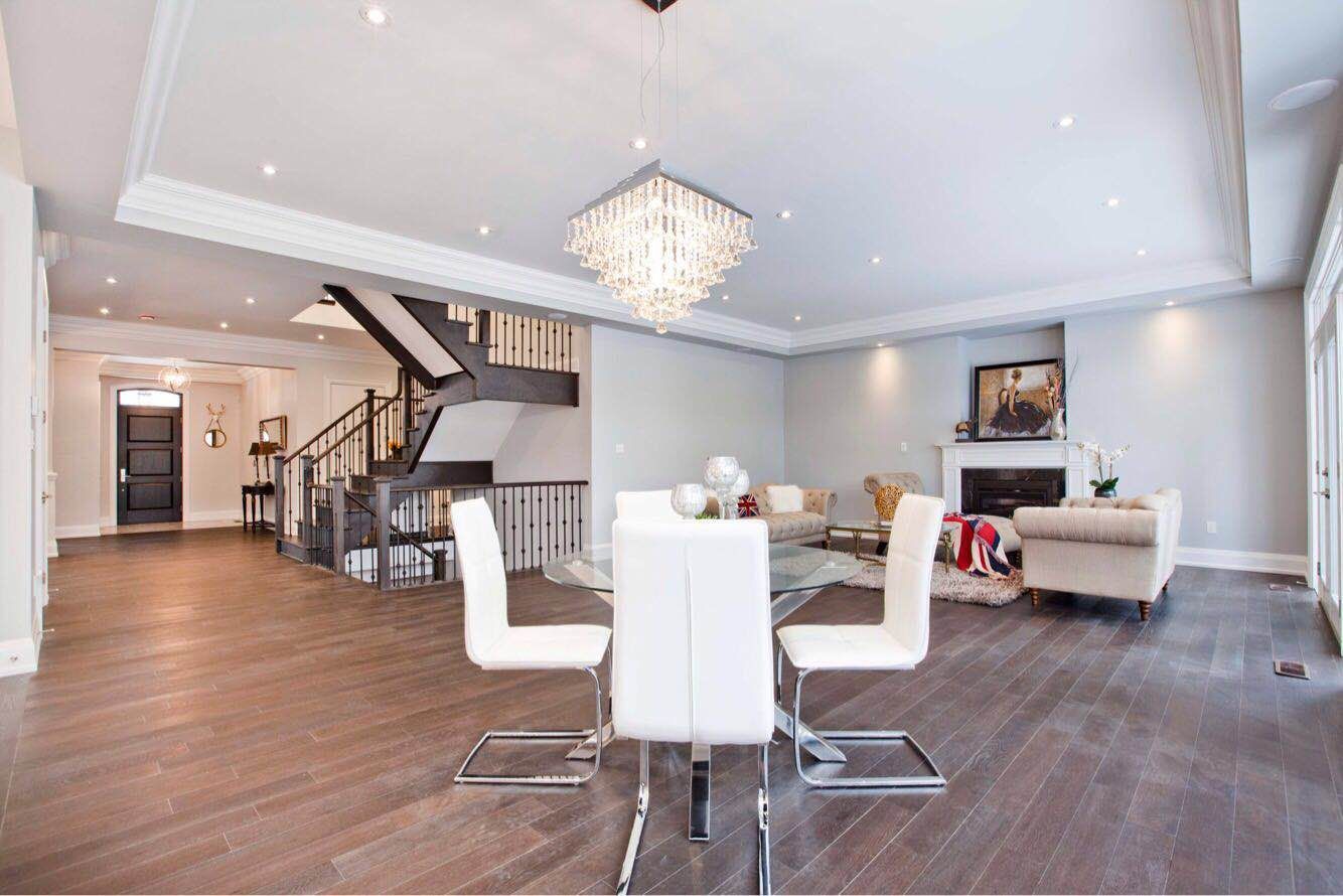 Spacious main floor interior completed through a Toronto design build custom build project, featuring an open-concept layout that connects the dining area, living room, and custom staircase. Hardwood flooring, recessed lighting, and elegant finishes highlight the craftsmanship of this whole house renovation Toronto project, creating a bright and functional living space designed for modern luxury homes in Toronto.