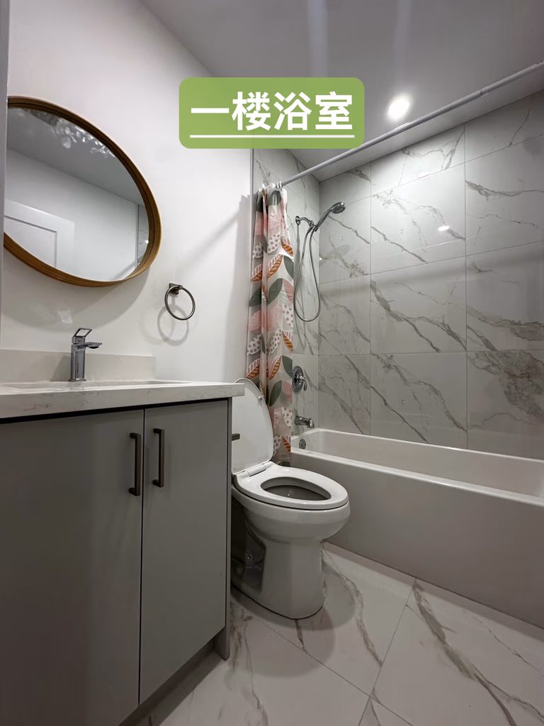 This main floor bathroom features a modern design with full bathtub, vanity, and upgraded finishes. As part of a Toronto legal 3-unit conversion, the space supports independent living and enhances rental appeal.