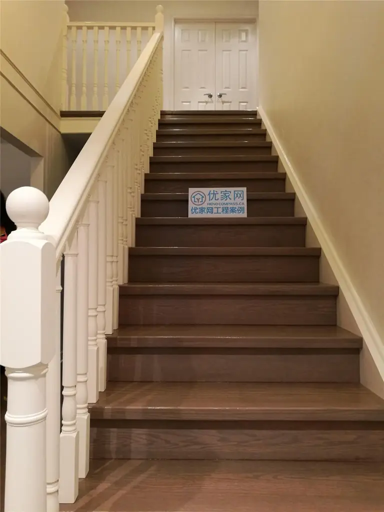 This image highlights a completed staircase flooring renovation in North York, featuring hardwood stair treads paired with classic white railings and balusters. The dark wood finish on the stairs creates strong visual contrast while maintaining a warm and timeless interior aesthetic. Precise stair installation improves safety, durability, and overall visual continuity between levels. This North York flooring renovation demonstrates skilled craftsmanship and careful detailing, delivered by a professional Toronto renovation company specializing in flooring and staircase upgrades.