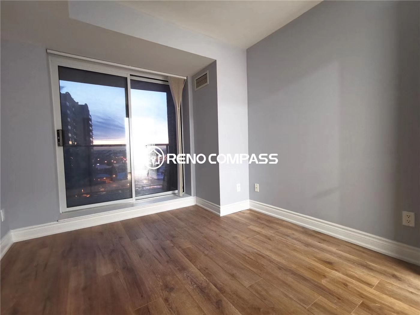 This Richmond Hill condo bedroom renovation features newly installed wood flooring, fresh wall finishes, and updated interior details to create a clean and modern living space. Large sliding balcony doors allow for natural light and city views, enhancing the overall comfort and openness of the room. The renovation focuses on improving both aesthetics and functionality within a condominium layout. Completed by Reno Compass, a professional Toronto renovation company, this project highlights efficient condo interior upgrades designed to elevate everyday living and increase property value.