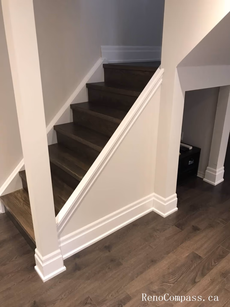 Richmond Hill basement renovation showcasing newly finished staircase with dark wood steps, upgraded baseboards, and clean modern trim work. This basement upgrade enhances safety, durability, and visual continuity, creating a seamless transition between floors with high-quality craftsmanship and contemporary design.