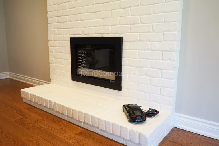 This North York interior renovation features a refreshed fireplace design with a modern electric insert and beautifully finished white brick feature wall. The clean brick texture and updated hearth create a cozy yet contemporary focal point, enhancing both comfort and visual appeal. Completed by Reno Compass Inc., providing professional interior renovation and fireplace upgrade services across North York and the Greater Toronto Area.